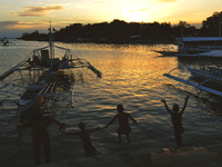 Four young boys dives into the waters at a public beach on 3rd March 2015 in Lapu Lapu City, Cebu, Philippines. With classes about to end an...
