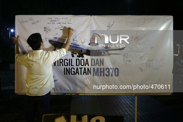 A man writes a message on a board for the missing Malaysian Airlines MH370 in Petaling Jaya near Kuala Lumpur, Malaysia 6 March 2015. On 8 J...