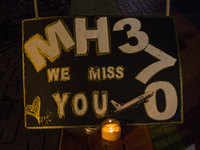 A candle is placed near a board for an event of the missing Malaysian Airlines MH370 in Petaling Jaya near Kuala Lumpur, Malaysia 6 March 20...