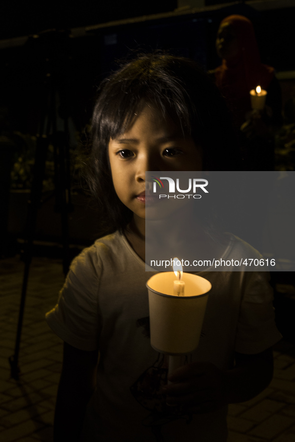 A young girl holds a candle as she take part in an event for the missing Malaysian Airlines MH370 in Petaling Jaya near Kuala Lumpur, Malays...