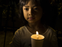 A young girl holds a candle as she take part in an event for the missing Malaysian Airlines MH370 in Petaling Jaya near Kuala Lumpur, Malays...