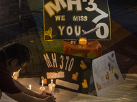 A man lights a candle during an event for the missing Malaysian Airlines MH370 in Petaling Jaya near Kuala Lumpur, Malaysia 6 March 2015. On...