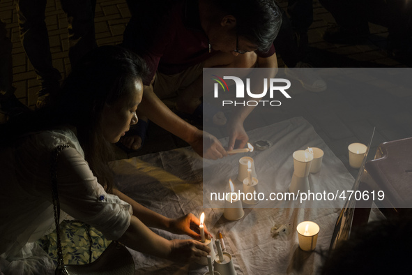 Kelly Wen, wife of a missing passenger lights a candle as she take part in an event for the missing Malaysian Airlines MH370 in Petaling Jay...