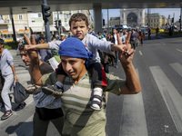 Hundreds of migrants walk through the streets of Budapest after leaving the transit zone at Budapest Keleti railway station in Budapest, Hun...