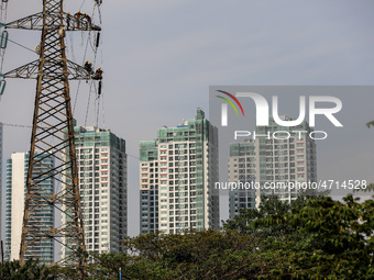 Operators work on a high voltage tower in Jakarta, Indonesia, July 27, 2019.  (