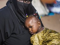 Mother with her baby in a praying demonstration in Ouagadougou, Burkina Faso. (
