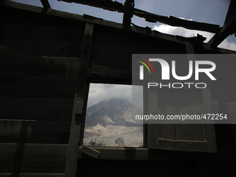 
In this photo taken on March 7, 2015, Mount Sinabung framed by a building collapse caused by the eruption of Mount Sinabung from the recen...