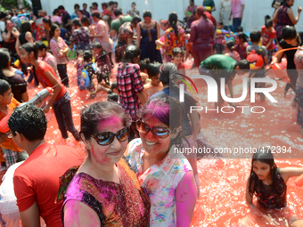 Two hindu devotees (center front) poses for a picture as other enjoy during the Holi Festival in Bangkok, Thailand on March 8, 2015. (