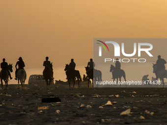Palestinians enjoy the Gaza beach at sunset, on March 9, 2015. (
