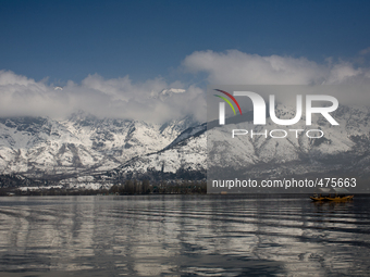 SRINAGAR, KASHMIR, INDIA - MARCH 10: Snow capped Zabarvan mountains are reflected in Dal lake  on March 10, 2015 in Srinagar, the summer cap...