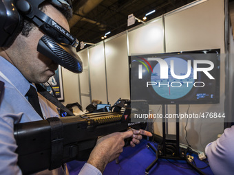 A man carries 3D glasses and a electronic fusil in a fight simulator in the spanish army stand during the security fair HOMSEC in Madrid, Sp...