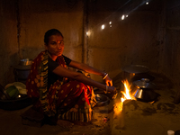 A woman cooking inside her house in Khadim Tea Estate in Sylhet, Bangladesh. (