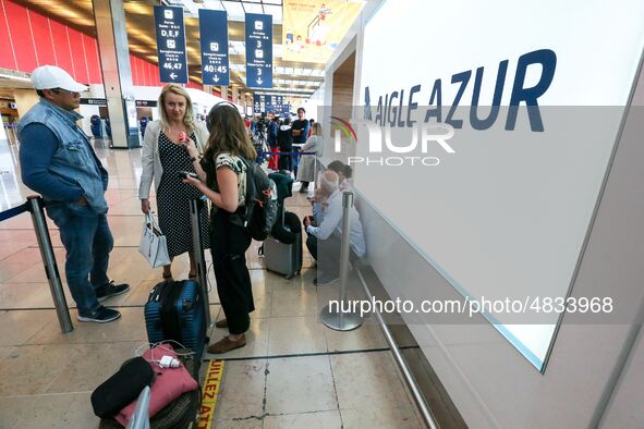 Passengers wait in front of the French airline Aigle Azur’s reception desk, without any employees, at Orly airport, France  on September 6,...