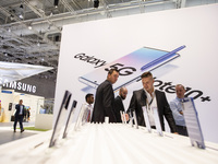 Visitors with the background of the 5G Note 10+ smartphone advertisement at Samsung boot during the international electronics and innovation...