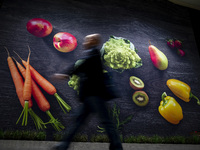 A man walks by a wall with the pictures of vegetables at Lieherr boot during the international electronics and innovation fair IFA in Berlin...