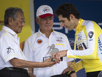 Algerian rider Youcef Reguigui ( R ) of MTN Qhubeka team receives a trophy from former Malaysian prime minister, Mahathir Mohamad ( L ) afte...