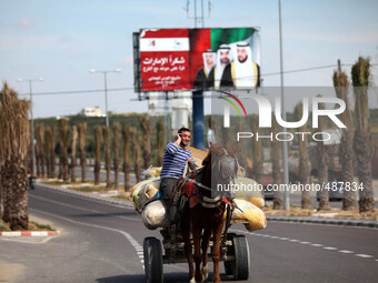  Palestinians drive past a billboard with pictures depicting UAE President Sheikh Khalifa bin Zayed al-Nahayan (R), Abu Dhabi Crown Prince S...