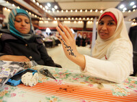  Palestinian women show their hands painted with traditional henna tatoos during the Palestinian heritage entitled 