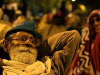 An Indian farmer rests on a road as he attends a huge gathering of farmers near the parliament for a protest against the land acquisition bi...