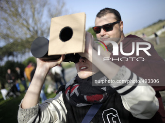 People tries to catch a glimpse of a solar eclipse in Vigo, Spain on March 20, 2015. A partial eclipse of varying degrees is visible, depend...