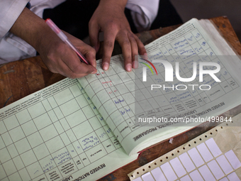 SRINAGAR, INDIAN ADMINISTERED KASHMIR KASHMIR, INDIA - MARCH 23: A health care professional adds red mark on the register after testing posi...