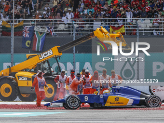 Track Marshall assist Swedish Marcus Ericsson of Sauber F1 Team car during the Malaysian Formula One Grand Prix at Sepang International Circ...