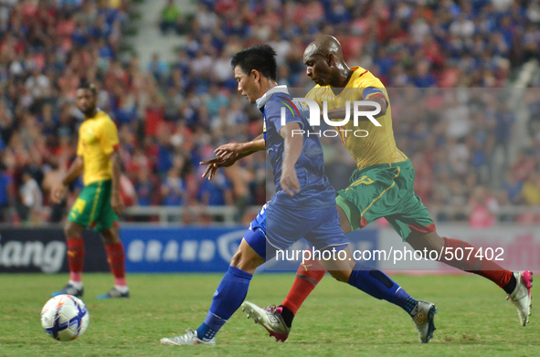Stephane Mbia (R) of Cameroon vies with Prakit Deeprom of Thailand during the international friendly match between Thailand and Cemeroon at...