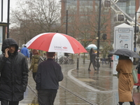 People sheltering underneath umbrellas, due to the heavy rain, on Monday 30th March 2015. (