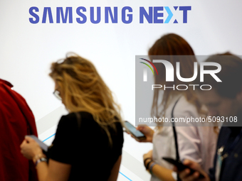 The Samsung logo is pictured as people check the phones during the annual Web Summit technology conference in Lisbon, Portugal on November 6...