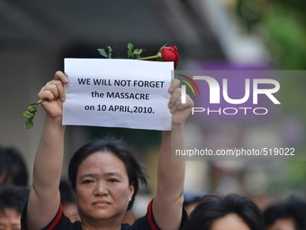 An activist holds a sign reading 'We will not forget the massacre on 10 Aprill, 2010' during the 2010 bloody crackdown memorial at Democracy...