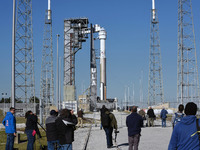 Members of the media photograph Boeing's first CST-100 Starliner spacecraft as it sits atop a United Launch Alliance Atlas V rocket on pad 4...