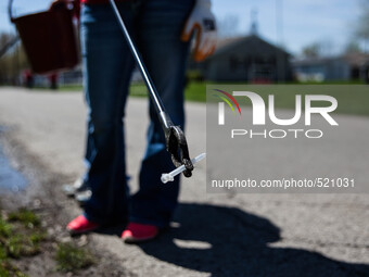 A volunteer holds a used syringe found a long a ditch line on Church St. in Austin Indiana April,11,2015.  a short-term needle exchange prog...