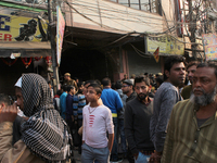 People gather at Anaj Mandi area near Rani Jhansi Road where a fire broke out during early morning hours in a plastic factory, on December 8...