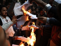People burn a copy of a Citizenship Amendment Bill, passed by Indian Parliament on Monday, granting Indian citizenship to migrants of all of...