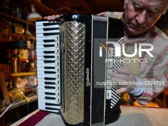 Former theatre actor and long time artist and luthier, Jozef Gmyrek (age 71), tunes an accordion in his workshop.    
His work is not a job...