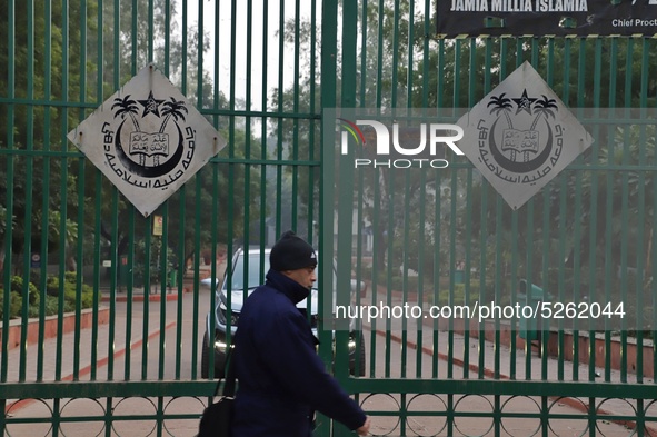 A man walks past the gate of Jamia Millia Islamia University, in New Delhi, India on 23 December 2019 