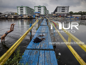  A child swim at sea in North Jakarta. Besides floods that always hit the capital city of Indonesia, Jakarta is one of the fastest-sinking c...