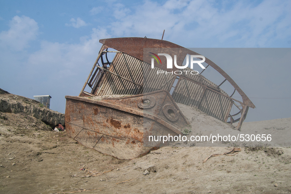 A sunken passenger vessel sits grounded on Kamarjani island, near Gaibandha, Bangladesh on 20 January 2015. Local people say that there are...