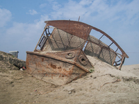 A sunken passenger vessel sits grounded on Kamarjani island, near Gaibandha, Bangladesh on 20 January 2015. Local people say that there are...