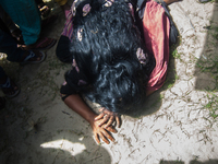 A women crawls on the ground at the Mawa Ferry Ghat on August 4, 2014 after her husband went missing when the Pinak-6 passenger vessel sank...