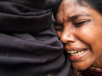 A women is cries with her family members at the Mawa Ferry Ghat near Dhaka, 3 August 2014 after her husband and only son went missing after...