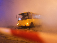 A bus is seen in a pit on the road, after a central heating pipe accident in the central district of Kyiv, Ukraine, on 13 January, 2020. As...