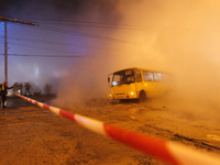 People take a photo of a bus in a pit on the road, after a central heating pipe accident in the central district of Kyiv, Ukraine, on 13 Jan...