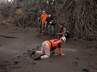 Rescuers crawl through soft soil as they search animals left behind by residents of the Taal Volcano Island in Batangas province, south of M...