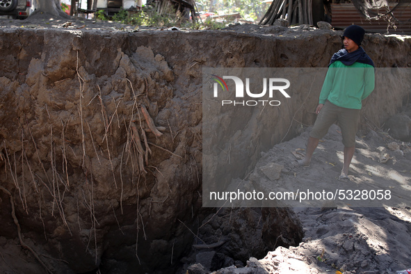  A boy stands on a crack in the ground after earthquakes caused by the Taal volcano in Talisay, in the province of Batangas on 16 January 20...