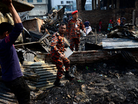 Bangladeshi firefighters seen searching after a devastating fire that broke out at Chalantika slum last night in Dhaka, Bangladesh, on Janua...
