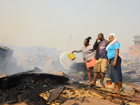 Shop owners with detergent water trying to put out a fire that broke out at the popular timber market in Mushin, Lagos January 25, 2020. The...