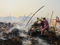  Two men with bowl of water trying to put out a fire that broke out at the popular timber market in Mushin, Lagos January 25, 2020. There ha...