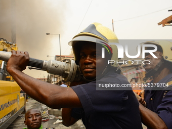  Team of fire fighters extinguishing a fire after a fire broke out in a section of the balogun market in Lagos Island on January 29, 2020....