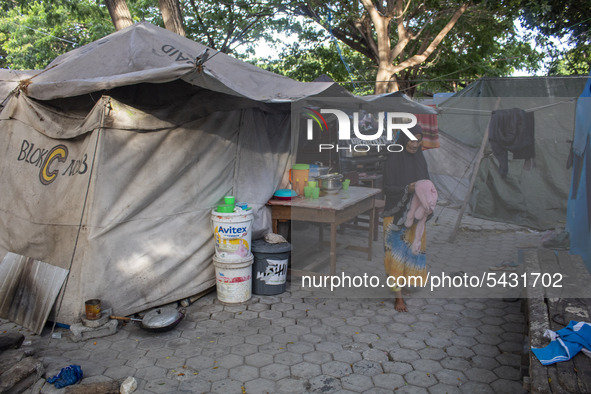 A disaster survivor mother is active in front of her emergency tent at the Agung Mosque shelter in Palu, Central Sulawesi, Indonesia on Febr...